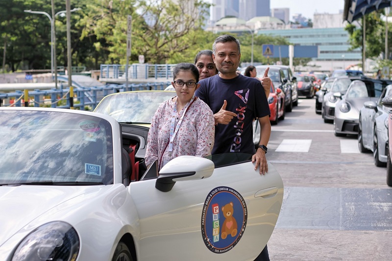 A family of participants get ready to ride in a Porsche around the island of Singapore // Credit: Duke-NUS